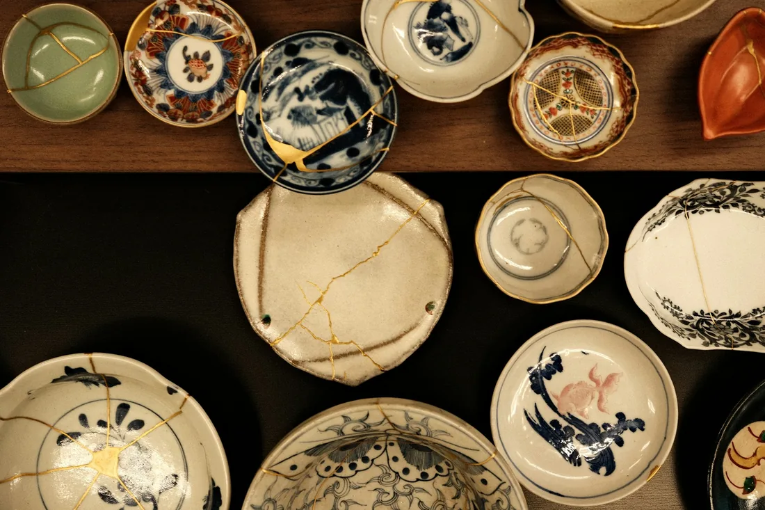 Keramické misky a talíře opravené technikou kintsugi se zlatými spoji